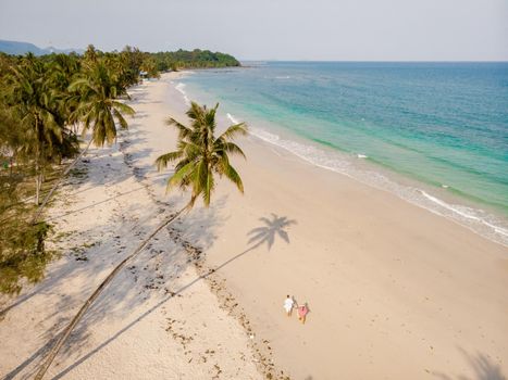 couple on vacation in Thailand, Chumpon province, white tropical beach with palm trees, Wua Laen beach Chumphon area Thailand, palm tree hanging over the beach with a couple on vacation in Thailand.