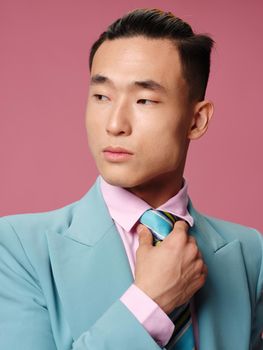 Man Asian appearance blue suit tie self-confidence businesswoman pink background. High quality photo