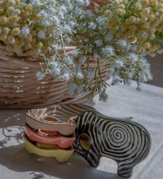 Set of Elephants shaped ceramics cup and bouquet of flowers in woven basket to Decorate the house beautifully. Elephants shaped cup for dipping sauce, No focus, specifically.