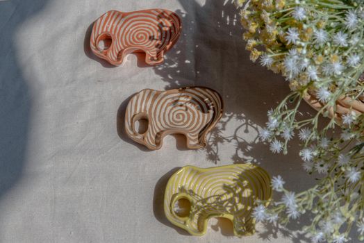 Set of Elephants shaped ceramics cup and bouquet of flowers to Decorate the house beautifully. Elephant shaped cup for dipping sauce, Copy space, Selective focus.