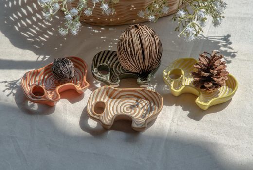 Set of Elephants shaped ceramics cup and Dried cerbera oddloam's seed, Pine cone to Decorate the house beautifully. Elephants shaped cup for dipping sauce, Selective focus.