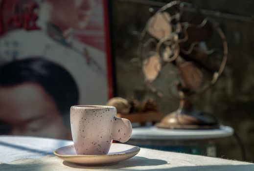 Beautiful pink ceramic mug in Chinese retro style room with old ruins cement wall. No focus, specifically.