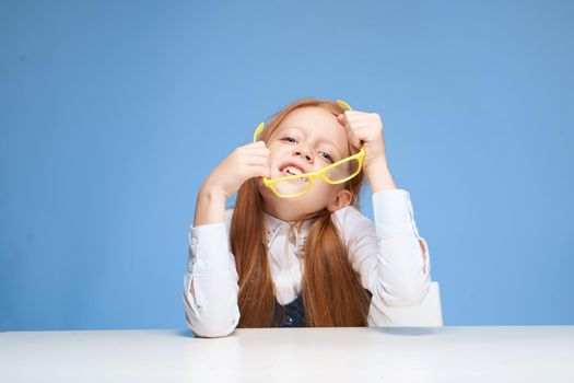 emotional schoolgirl sitting at the table learning school. High quality photo
