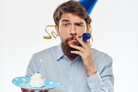 A man with a cake plate and in a blue shirt on a light background birthday party corporate cap. High quality photo