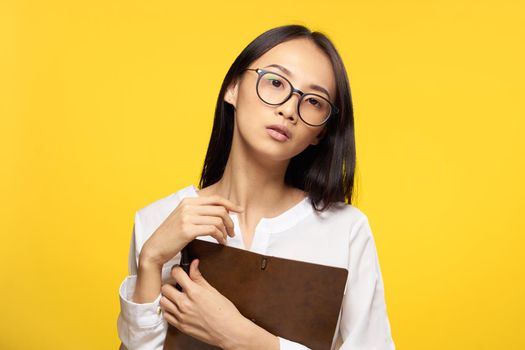 elegant woman with notepad in hands official office yellow isolated background. High quality photo
