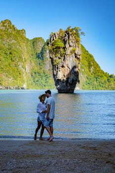 James Bond island near Phuket in Thailand. Famous landmark and famous travel destination, couple men and woman mid age visiting James Bond island in Krabi Thailand. European man and Asian woman on vacation