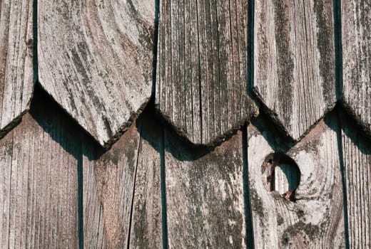 Fragment of the wall of an old rural house made of wooden planks. Background texture of old wooden wall. 