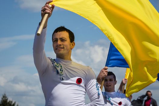 KIEV, UKRAINE - May. 09, 2015: Young people with flags of Ukraine during Victory Day celebrations in the square next to the National Museum of the Great Patriotic War