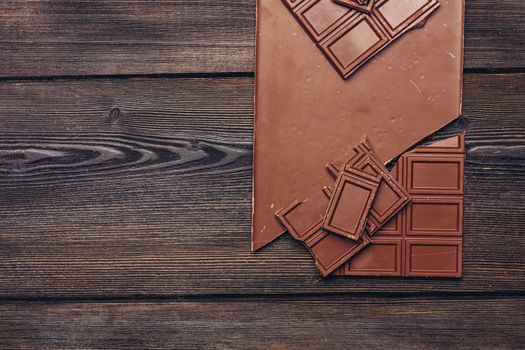 sweet chocolate bar on wooden background and sweets candy texture. High quality photo