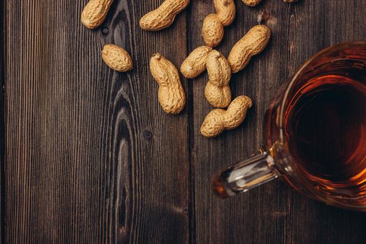 beer mug peanuts in shell wooden table top view. High quality photo