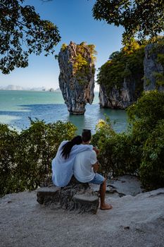 James Bond island near Phuket in Thailand. Famous landmark and famous travel destination, couple men and woman mid age visiting James Bond island in Krabi Thailand. European man and Asian woman on vacation