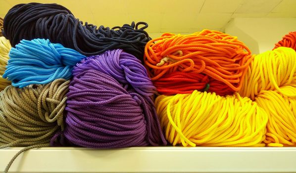 A bunch of colorful shoelaces. A bunch of colorful threads for sports shoes, lying on a shelf in the store.