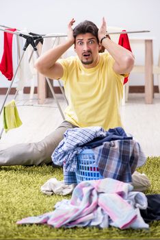 Handsome man husband doing laundering at home