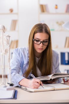 Student sitting in classroom and studying skeleton