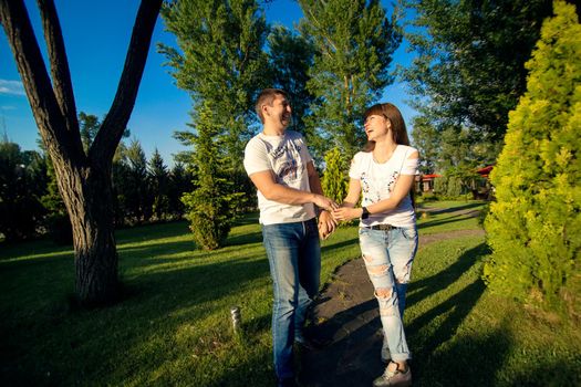 Young romantic couple have fun enjoy each other in green summer park.