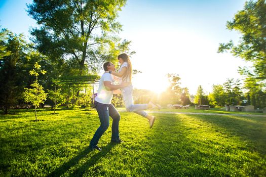 Young romantic couple have fun enjoy each other in green summer park.