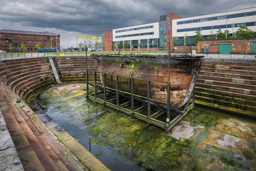 Belfast, Northern Ireland - June 27, 2017: The original caisson gate Hull No 50 stands on beside SS Nomadic at Hamilton Dock is oldest Harland and Wolff vessel anywhere in the world.