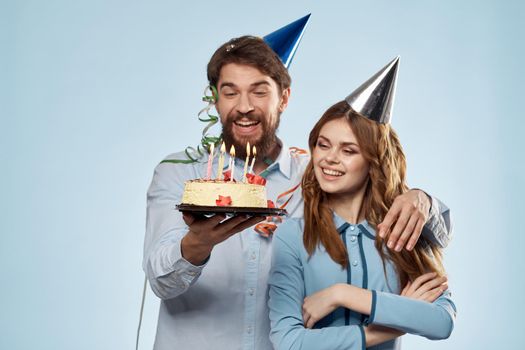 Emotional man with cake and pretty woman party disco blue background. High quality photo