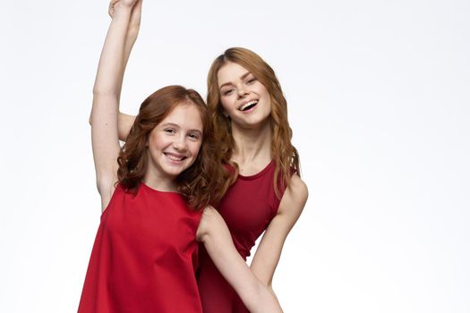 Mom and daughter stand side by side and fun family joy light background. High quality photo