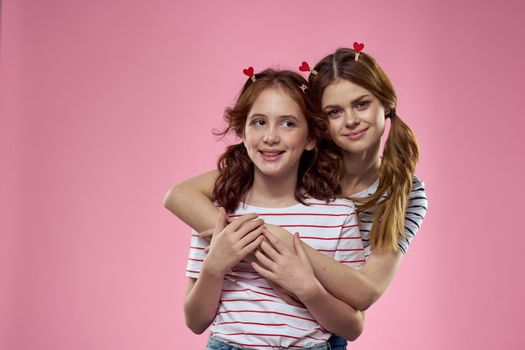Woman and little girl on a pink background fun sisters friends family. High quality photo