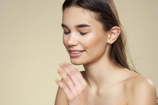 Pretty woman naked shoulders long hair body care beige background. High quality photo