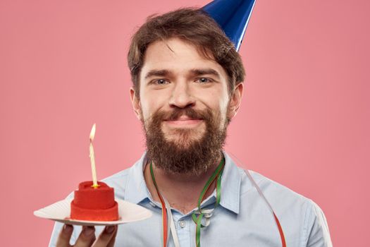 Happy car with a cake on a pink background and in a cap in Copy Space holidays birthday. High quality photo