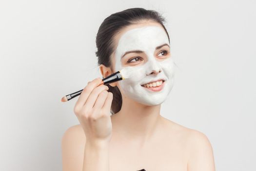 emotional brunette with face mask naked shoulders skincare. High quality photo