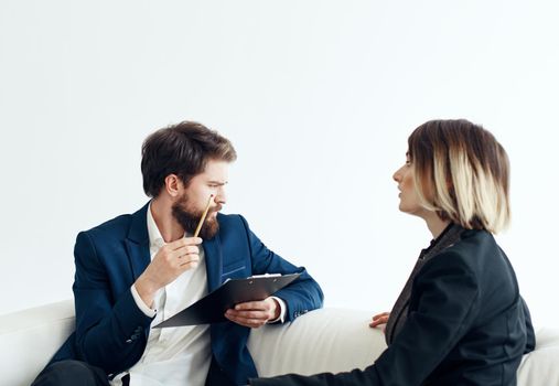 Business man and woman employees communicating on the couch indoors. High quality photo