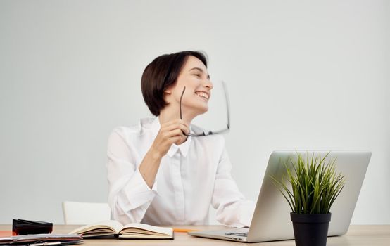 woman sitting at her desk wearing glasses in front of laptop office manager executive. High quality photo