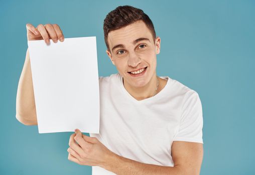 Man with white sheet of paper poster blue background mockup. High quality photo