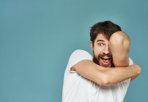 Close-up of a man gesturing with his hands on a blue background cropped view. High quality photo