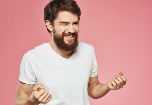 emotional man on pink background gesturing with his hands fun. High quality photo