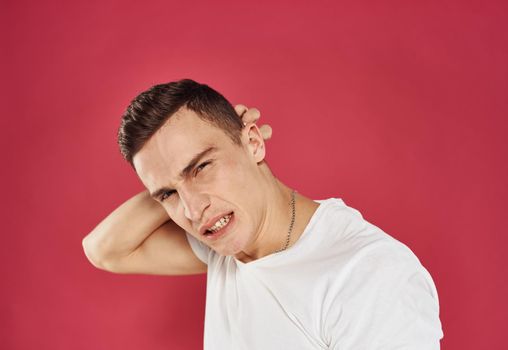 Man in white t-shirt displeased facial expression closeup emotion. High quality photo