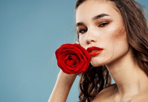 Sexy woman with bared shoulders and a red flower near the face. High quality photo