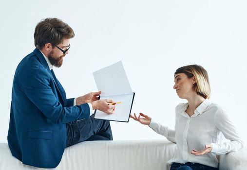 Work colleagues documents communication office documents white sofa. High quality photo