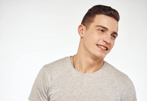 Handsome man in a T-shirt attractive look light background. High quality photo