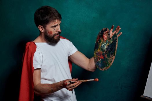 A man in a white T-shirt red cloak drawing art Green background. High quality photo