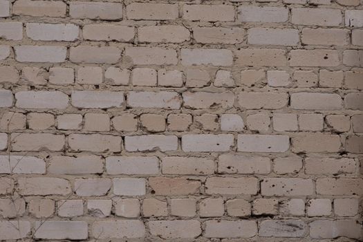 A brick white wall. The wall is poorly laid. Texture