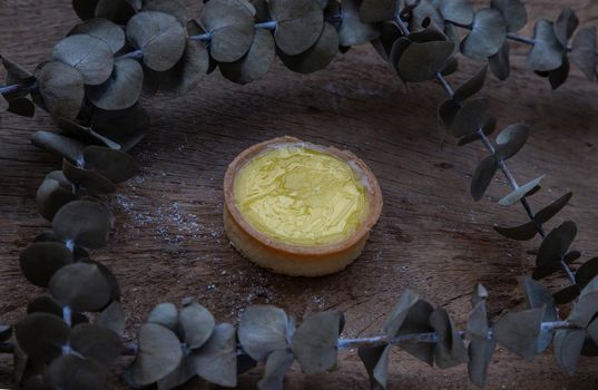 Lemon tart and Dried flowers on old rustic wooden table. Bakery and dessert concept, Selective focus.