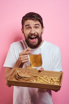 Bearded man beer fast food alcohol diet food pink background. High quality photo