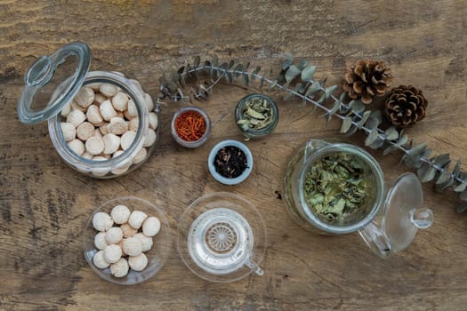 Morning refreshing with herbal tea which is served with Khanom Ping (Thai traditional dessert). The desserts is served on rustic wooden background. Thai style high tea, Selective focus.