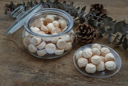 A type of Thai traditional dessert consisting of many small, made from flour, egg, coconut milk and sugar call Thai sweetmeat or Thai Mini Cookie or Khanom ping on rustic wooden table. Selective focus.