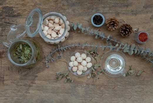 Morning refreshing with herbal tea which is served with Khanom Ping (Thai traditional dessert). The desserts is served on rustic wooden background. Thai style high tea, Selective focus.
