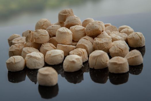 A type of Thai traditional dessert consisting of many small, made from flour, egg, coconut milk and sugar call Thai sweetmeat or Thai Mini Cookie or Khanom ping on black table.