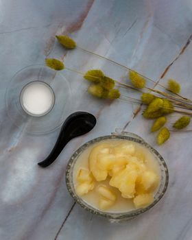 Cassava in syrup usually served with coconut milk on marble table. Traditional desserts in Thailand. Top view, Selective focus.