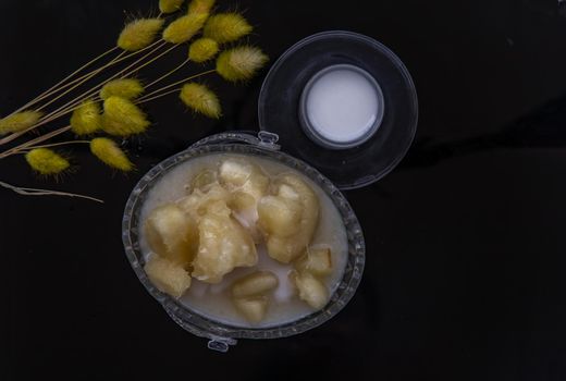 Cassava in syrup usually served with coconut milk on black table. Traditional desserts in Thailand. Top view, Selective focus.