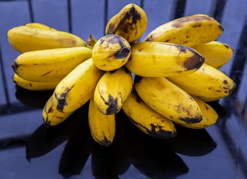 Bunch of Lady finger bananas.Tropical Fruit Natural Product on black table. Selective focus.