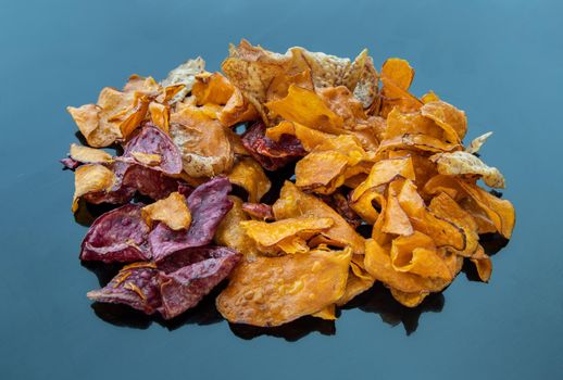 Mixed thai sweets made from sliced sweet potato coated with sugar (Potato chip) on blue table. Copy spce, Selective focus.
