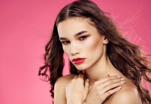 Portrait of an elegant lady with red lips on a pink background with bright makeup. High quality photo