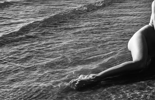 Beautiful girl outdoors enjoying nature. Young naked woman with scarlet dreadlocks enjoys the sea on the coast